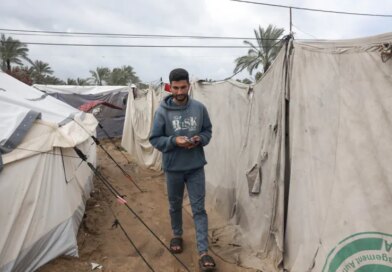 Abdel Karim Salman heads daily to the charging station to charge his phone and his wife’s phone, which they use as a source of light in their tent throughout the night [Abdelhakim Abu Riash/ Al Jazeera]