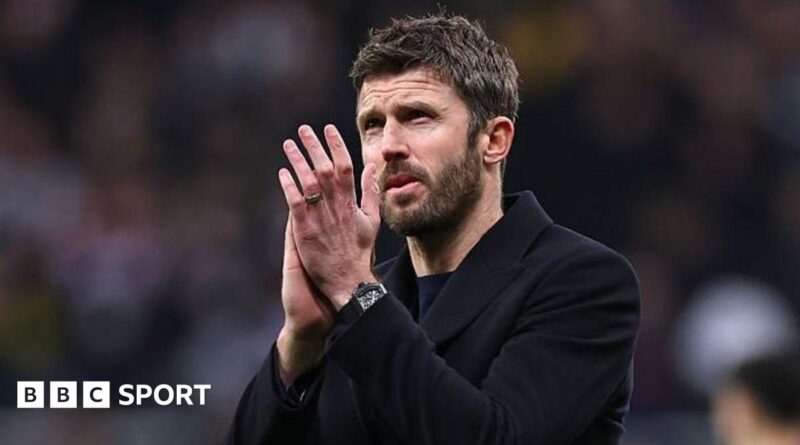 Michael Carrick, in a dark coat, applauds Manchester United fans