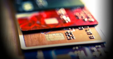 Close up macro color image depicting an abstract view of a collection of debit and credit cards and numeric digits.