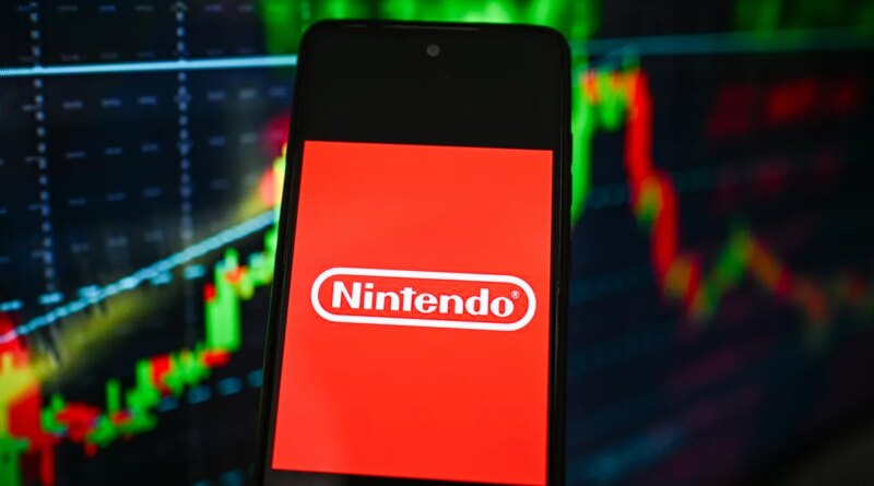 Nintendo logo is seen displayed on a smartphone with stock market percentages on the background.