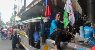 A driver sits on the bonnet of his jeepney in Manila amid protests in the Philippine capital over rising fuel prices [Michael Beltran/Al Jazeera]