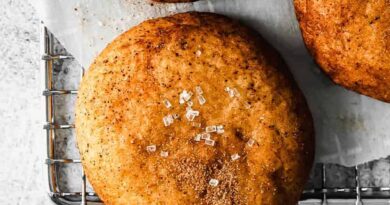 Four cinnamon buns on a cooling rack.