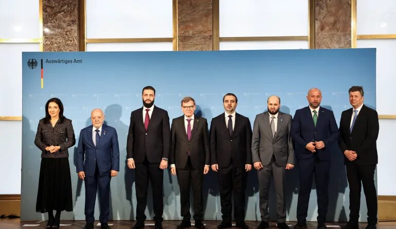 Syrian President Ahmed al-Sharaa and German Foreign Minister, Johann Wadephul, pose for a family photo with Syrian Minister of Emergency and Disaster Management, Raed al-Saleh, Member of the Executive Board of the Federation of German Industries, Wolfgang Niedermark, Syrian Foreign Minister, Asaad Hassan al-Shaibani, Syrian Economy Minister, Mohammad Nidal al-Shaar, Syrian Energy Minister, Mohammed Al-Bashir and German Economy and Energy Minister, Katherina Reiche, in Berlin, Germany, March 30, 2026. REUTERS/Nadja Wohlleben