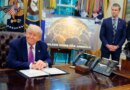 Golden Dome missile program placard with Trump sitting at desk