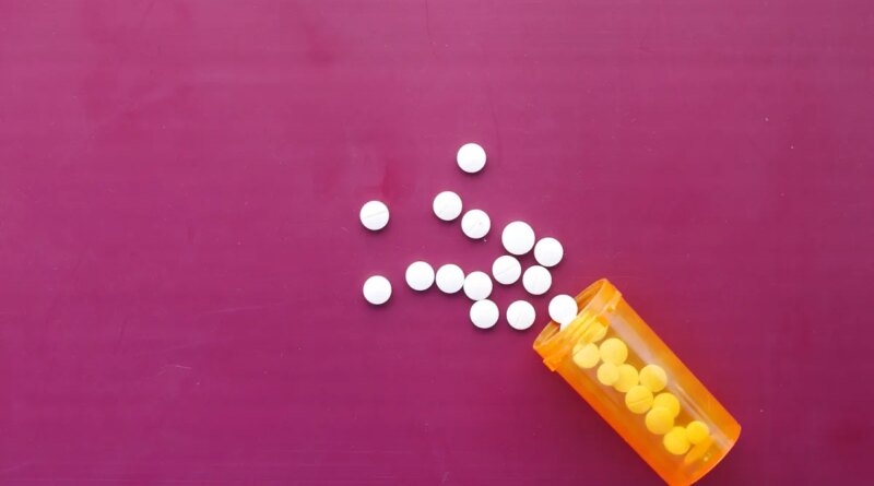 white color medical pills spilling on pink ,