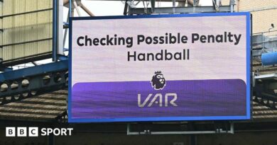 A big screen display a VAR check for a possible penalty during a Premier League match