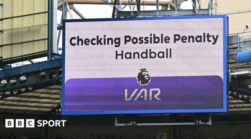 A big screen display a VAR check for a possible penalty during a Premier League match