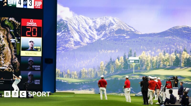 A man hitting a shot on an indoor golf simulator