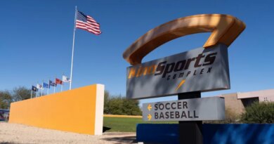 The American flag flutters near a sign pointing to the soccer stadium at Kino Sports Complex, where the Iranian men’s soccer team is scheduled to practice for the FIFA World Cup, in Tucson, Arizona