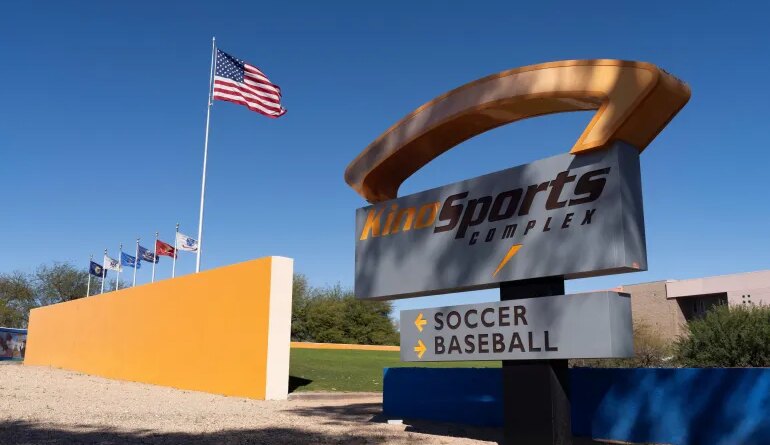 The American flag flutters near a sign pointing to the soccer stadium at Kino Sports Complex, where the Iranian men’s soccer team is scheduled to practice for the FIFA World Cup, in Tucson, Arizona