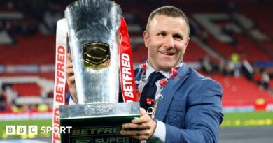 Hull KR coach Willie Peters holds the Super League trophy