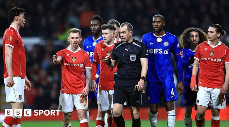 Lewis O'Brien of Wrexham speaks to Referee Peter Bankes as a VAR review takes place