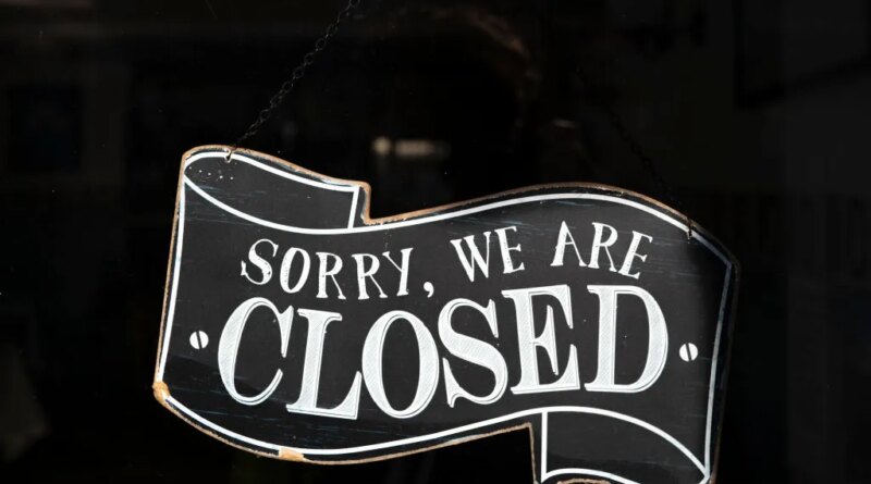 A closed sign in the window of a small business