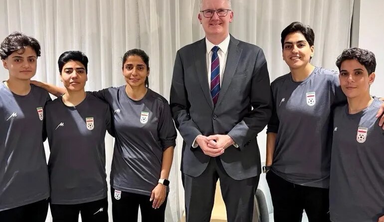 An undated and unplaced photo released by Australia's Department of Home Affairs shows Home Affairs minister Tony Burke (3/R) with five Iranian women football players who applied for asylum after competing in the Women's Asia Cup tournament being played in Australia. Australia has granted asylum to some of Iran's visiting women's football team over fears they faced persecution at home for not singing the national anthem before a match, Home Affairs Minister Tony Burke said on Tuesday. (Photo by HANDOUT / AUSTRALIAN DEPARTMENT OF HOME AFFAIRS / AFP) / ----EDITORS NOTE ----RESTRICTED TO EDITORIAL USE MANDATORY CREDIT " AFP PHOTO / DEPARTMENT OF HOME AFFAIRS" NO MARKETING NO ADVERTISING CAMPAIGNS - DISTRIBUTED AS A SERVICE TO CLIENTS