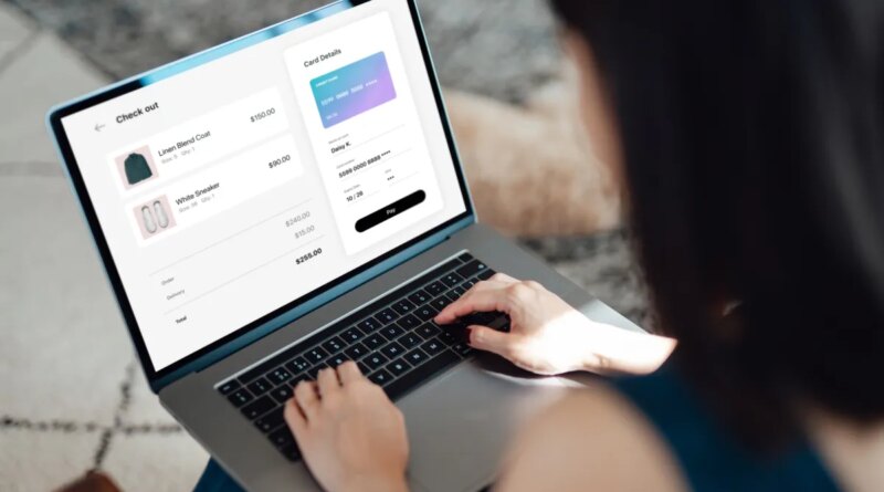 Above the shoulder view of a young Asian woman shopping clothes online on laptop, making payment with credit card. Enjoying seasonal sales. Shopaholic concept. Cyber security idea. Close up shot. Laptop screen mockup.