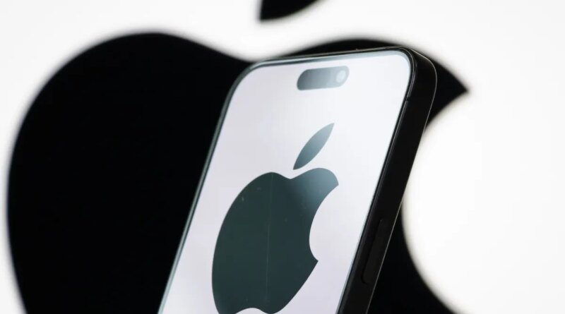 In this photo illustration, the logo of Apple Inc. is displayed on a smartphone screen, with the company's iconic black apple symbol visible in the background.
