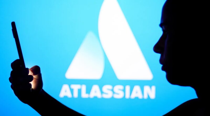 an Atlassian logo on a blue background with a person silhouetted in front holding a phone, for some reason