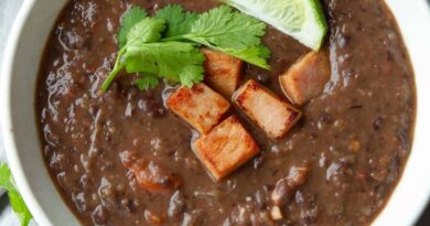 Black bean soup with hame and a lime wedge in a bowl.