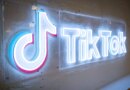 TikTok's neon logo and music note symbol on a concrete wall