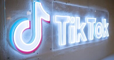 TikTok's neon logo and music note symbol on a concrete wall