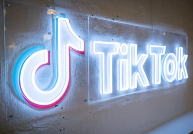 TikTok's neon logo and music note symbol on a concrete wall