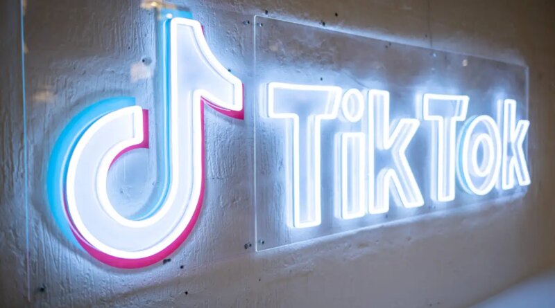 TikTok's neon logo and music note symbol on a concrete wall