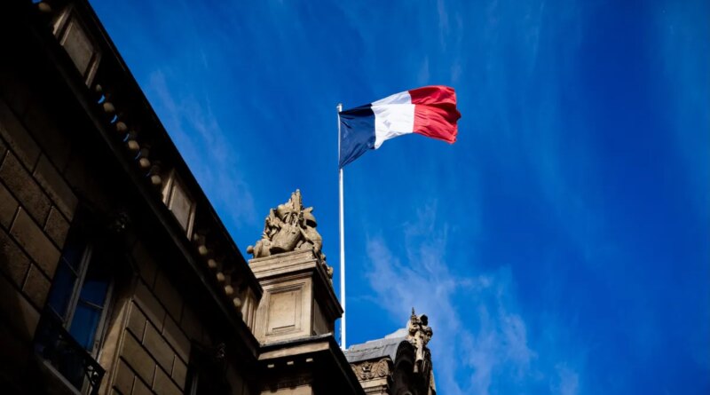 French tricolour flag (blue, white and red, symbol of the Republic of France) hanging from a flagpole above the entrance gate to the courtyard of the Elysee Palace, Exit from the Cabinet meeting at the Presidential Palace of the Elysee in Paris, France on August 27, 2025. The ministers get into their cars and leave the Elysee Palace. (Photo by Amaury Cornu / Hans Lucas via AFP)