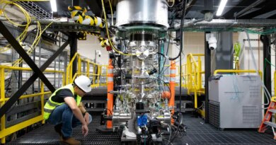 A worker inspects Zap Energy's Fusion reaction chamber.