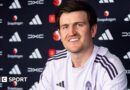 Harry Maguire smiling in a Manchester United news conference