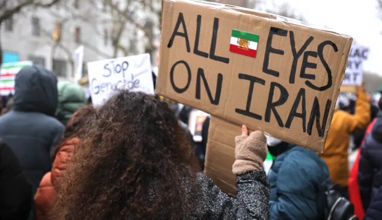 BERLIN, GERMANY - JANUARY 24: A protester holds a banner reading "All eyes on Iran" as people march in a demonstration held under the motto "Help Iran. No Business With The Mullahs" on January 24, 2026 in Berlin, Germany. Iranian officials have acknowledged that over 5,000 people were killed in the recent nationwide street demonstrations following violent suppression by government forces. (Photo by Omer Messinger/Getty Images)