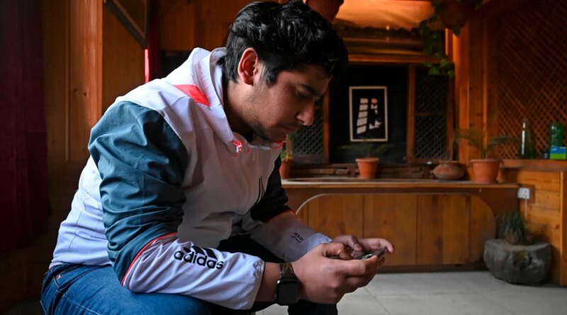 seated man looking at ell phone