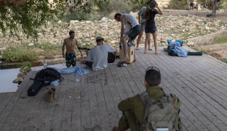 TOPSHOT - Israeli settlers gather at the Israeli-occupied West Bank village of Ras Ein al-Auja on April on April 9, 2026.