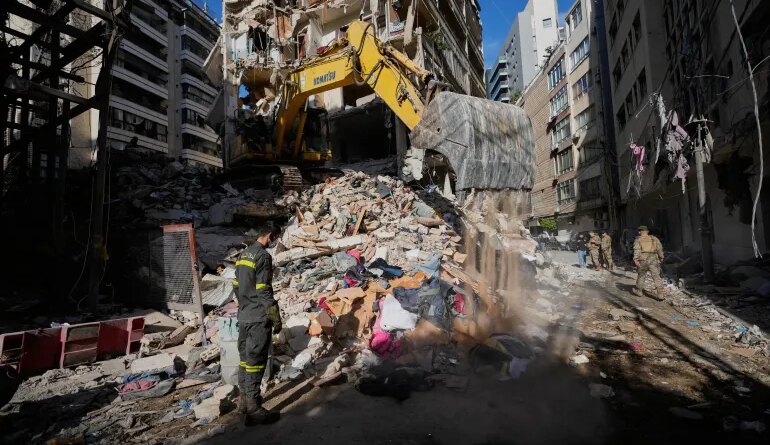 A Lebanese civil defense worker looks on as an excavator operates on the rubble of a building destroyed in an Israeli airstrike a day earlier in Beirut, Lebanon, Thursday, April 9, 2026. (AP Photo/Hussein Malla)