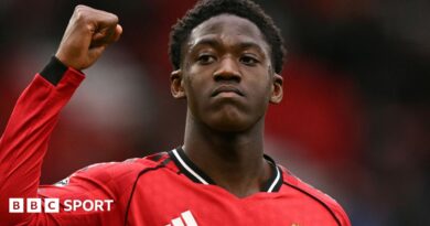 Kobbie Mainoo gestures to fans