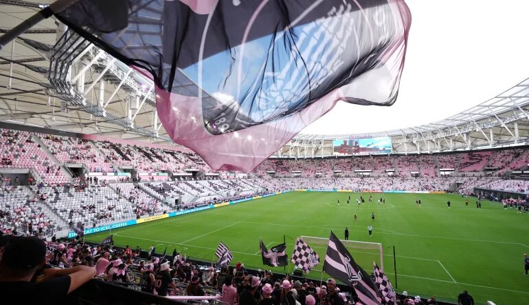Inter Miami fans wave flags in Nu Stadium ahead of the team's first MLS soccer match in their new home stadium, against Austin FC, Saturday, April 4, 2026, in Miami. (AP Photo/Rebecca Blackwell)