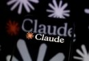 The Claude logo is displayed on a smartphone screen placed on a reflective surface onto which a multitude of Claude logos are projected.