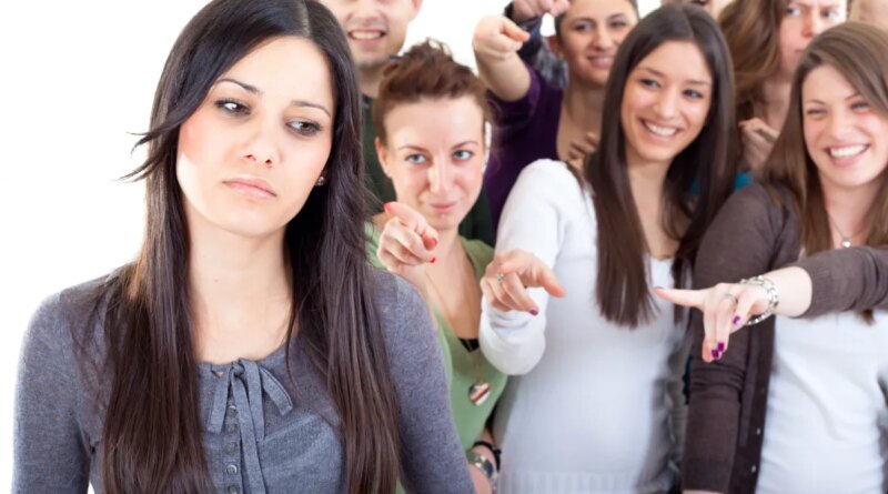 Crowd pointing fingers at a young woman