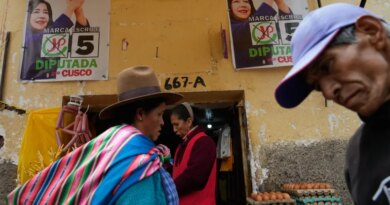 Pedestrians pass campaign signs before the weekend's presidential election in Cuzco, Peru, Wednesday, April 8, 2026. (AP Photo/Martin Mejia)