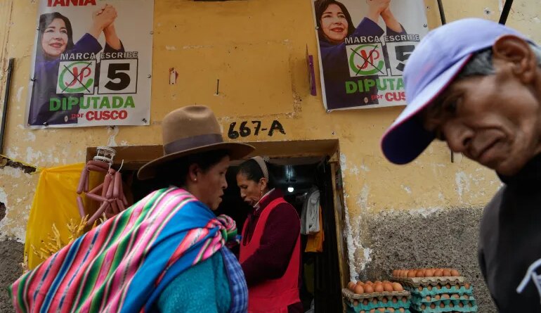 Pedestrians pass campaign signs before the weekend's presidential election in Cuzco, Peru, Wednesday, April 8, 2026. (AP Photo/Martin Mejia)