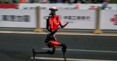 The fastest humanoid robot, an H1made by Honor, runs beside human runners at the start on its way to winning the Beijing Humanoid Half Marathon.
