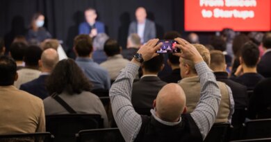An attendee at a StrictlyVC 2025 event taking a photograph