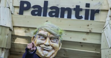 An activist dressed as U.S. President Donald Trump stands in front of a mock Trojan horse