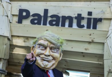 An activist dressed as U.S. President Donald Trump stands in front of a mock Trojan horse