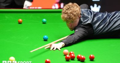 Stan Moody stretches over the snooker table to play a shot