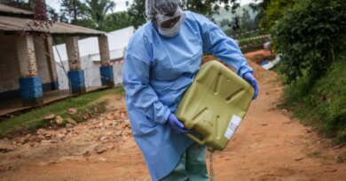 A health worker wearing protective equipment prepares disinfectant materials as she gets ready to disinfect the isolation area for Ebola patients at the General Referral Hospital of Mongbwalu in Mongbwalu [AFP]