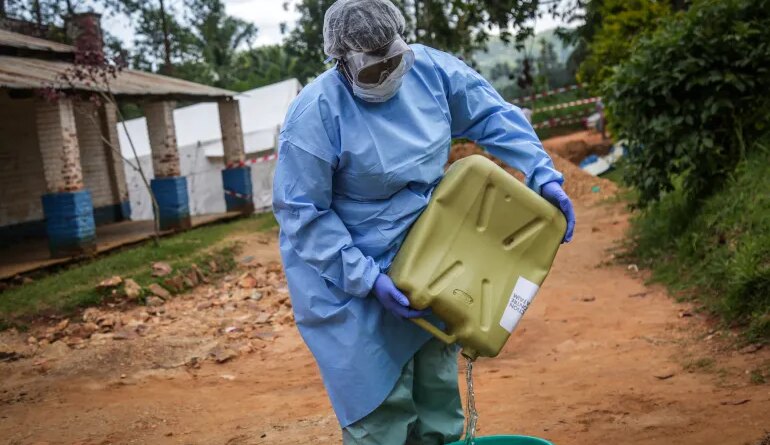 A health worker wearing protective equipment prepares disinfectant materials as she gets ready to disinfect the isolation area for Ebola patients at the General Referral Hospital of Mongbwalu in Mongbwalu [AFP]