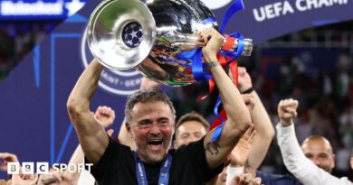 Paris St-Germain manager Luis Enrique smiling with the Champions League trophy