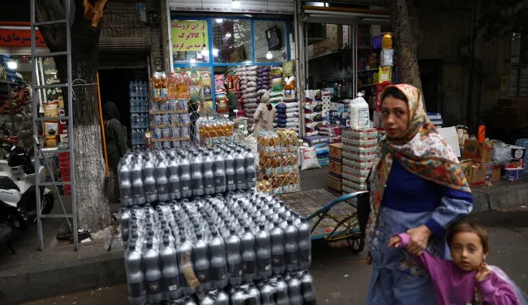 People walk in a local market in Tehran