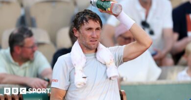 Casper Ruud pours water over his head during a change of ends
