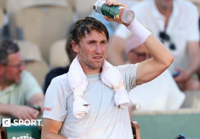 Casper Ruud pours water over his head during a change of ends